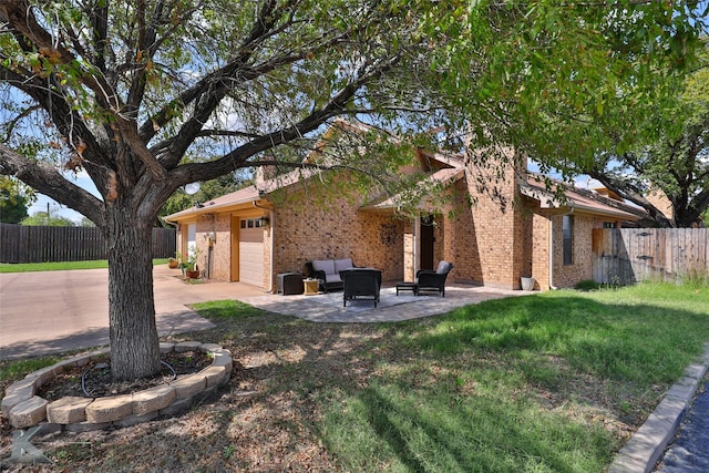 3153 Curry Ln Unit D3, Abilene, TX 79605 - view of side of home featuring brick siding, a patio, an outdoor hangout area, concrete driveway, and an attached garage