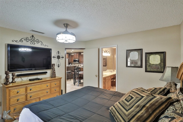 bedroom with connected bathroom and a textured ceiling