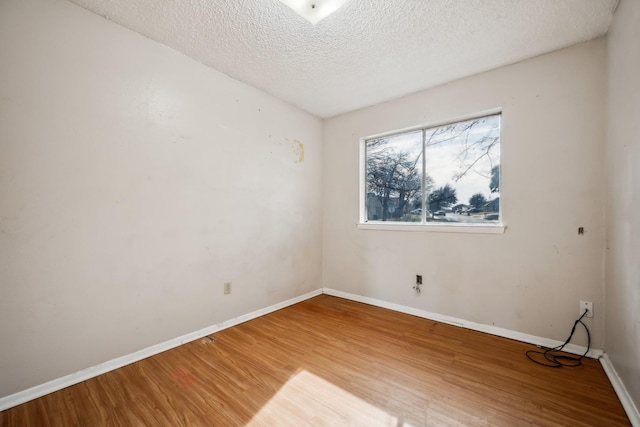 empty room featuring a textured ceiling and hardwood / wood-style floors