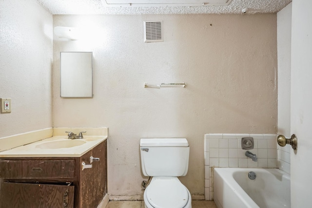 bathroom with toilet, vanity, a textured ceiling, and a bathtub