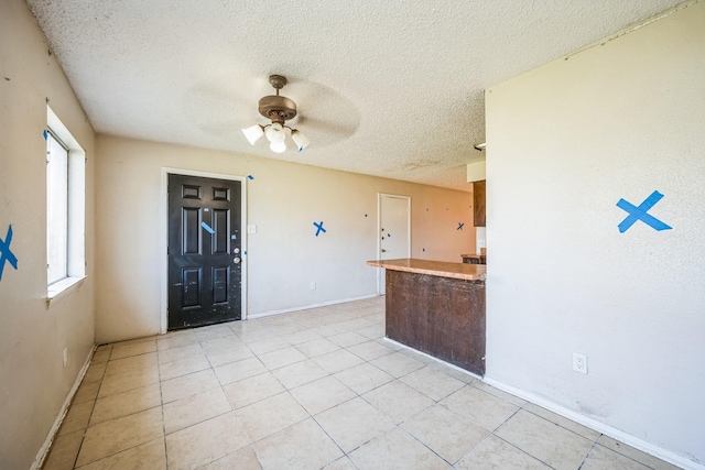 kitchen with a textured ceiling, ceiling fan, and light tile patterned flooring