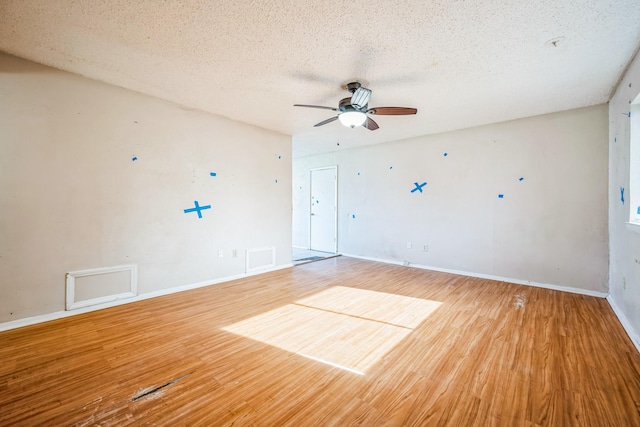 unfurnished room with a textured ceiling, ceiling fan, and light wood-type flooring