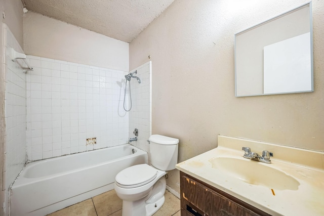 full bathroom with toilet, tile patterned floors, vanity, tiled shower / bath, and a textured ceiling