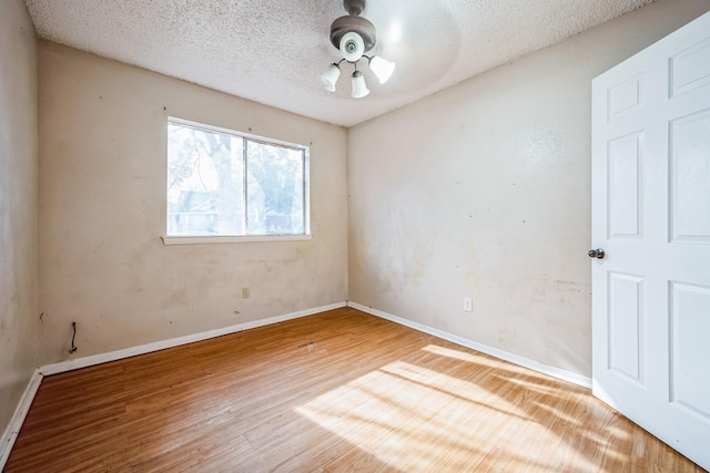 spare room featuring hardwood / wood-style flooring and a textured ceiling