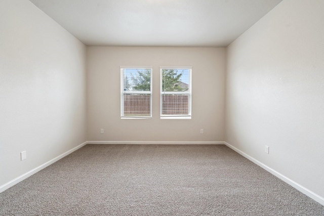 unfurnished room with baseboards and carpet