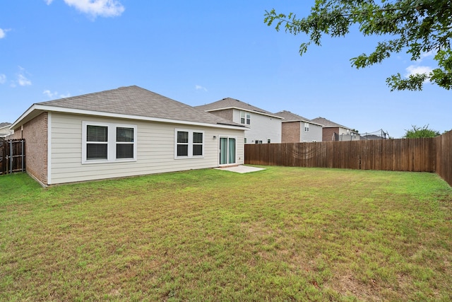 back of house featuring a patio and a yard