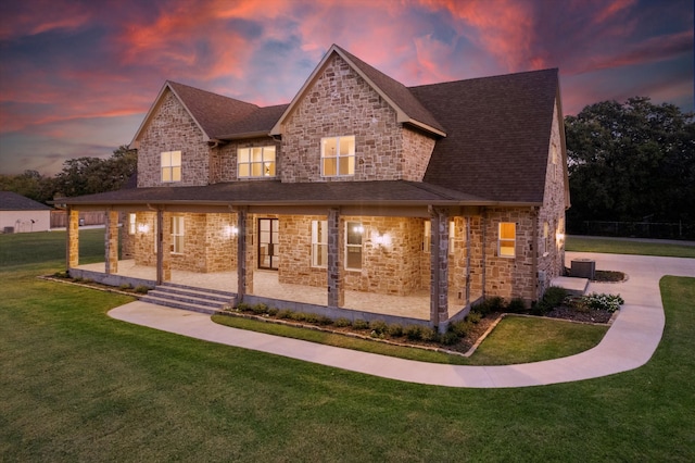 view of front of home featuring covered porch and a lawn