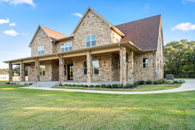 view of front of house featuring central air condition unit and a front lawn