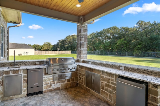 view of patio with exterior kitchen, sink, and a grill