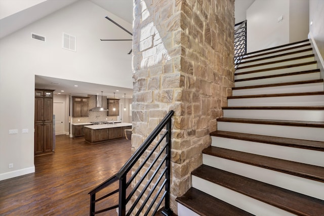 unfurnished living room with dark wood-type flooring, a high ceiling, and a fireplace