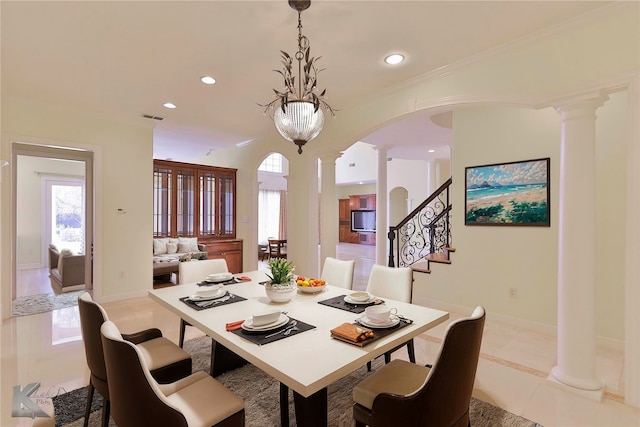 tiled dining room with ornate columns and an inviting chandelier