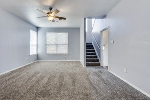 unfurnished living room with carpet and ceiling fan