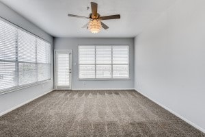 carpeted empty room with plenty of natural light and ceiling fan