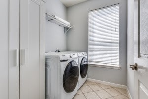 washroom featuring independent washer and dryer, plenty of natural light, and light tile patterned flooring