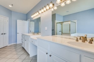 bathroom featuring walk in shower, vanity, and tile patterned floors