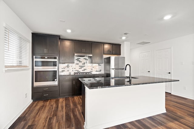 kitchen featuring dark hardwood / wood-style flooring, a kitchen island with sink, sink, and stainless steel appliances