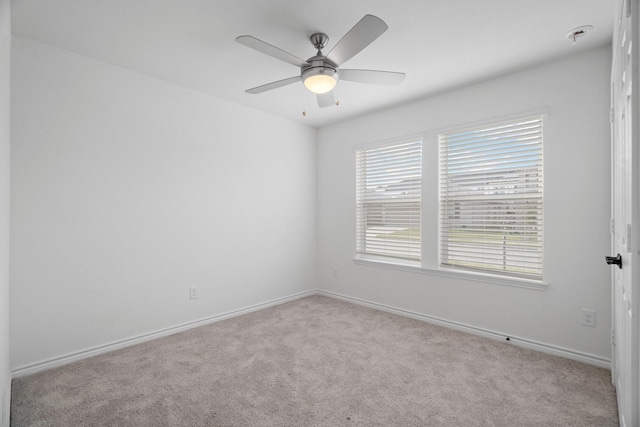 carpeted spare room with ceiling fan