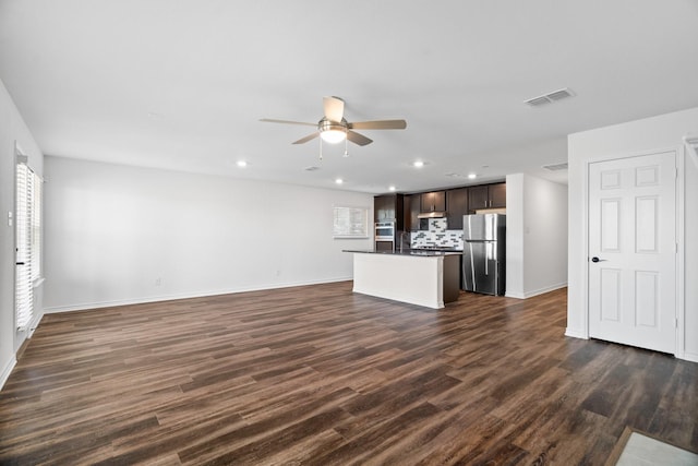 unfurnished living room featuring ceiling fan and dark wood-type flooring