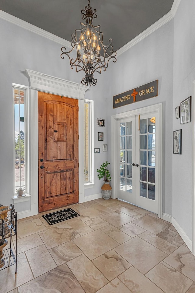 foyer with marble finish floor, baseboards, and ornamental molding