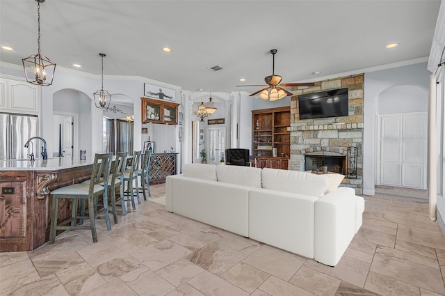 555 Mastadon Way, Weatherford, TX 76085 - living area featuring arched walkways, recessed lighting, ceiling fan, ornamental molding, and a stone fireplace