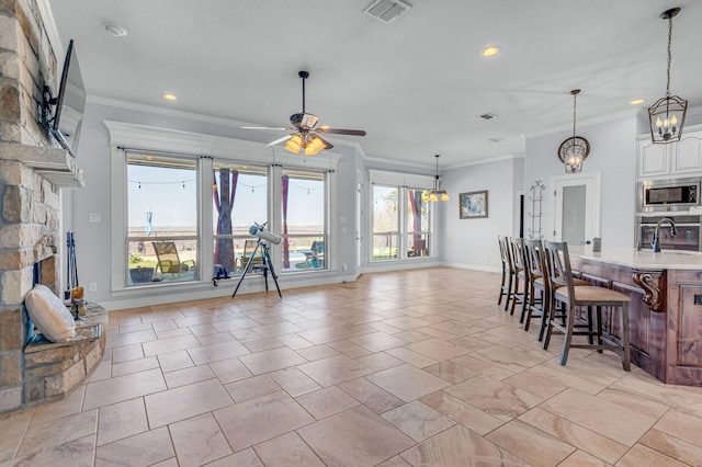 555 Mastadon Way, Weatherford, TX 76085 - kitchen with stainless steel appliances, a breakfast bar area, crown molding, light countertops, and recessed lighting