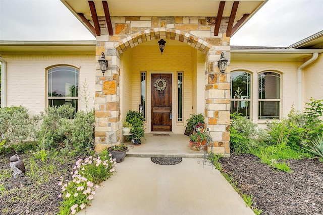 property entrance with brick siding and stone siding
