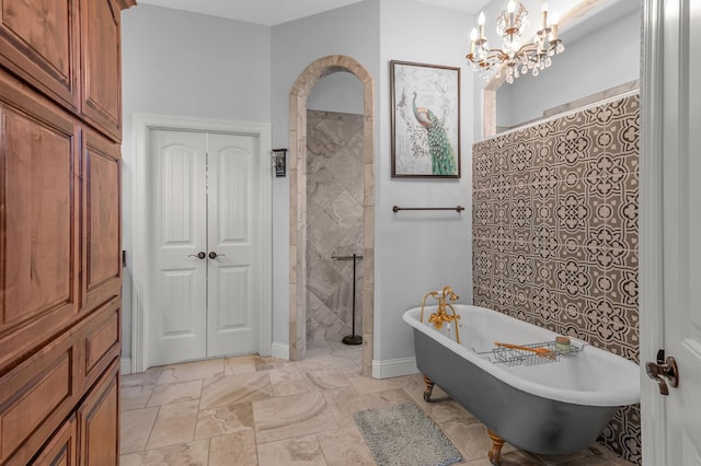 full bath with baseboards, a freestanding tub, a notable chandelier, and tiled shower