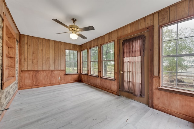 unfurnished sunroom featuring a healthy amount of sunlight and ceiling fan