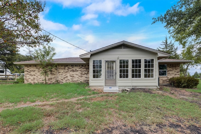 rear view of property featuring a yard