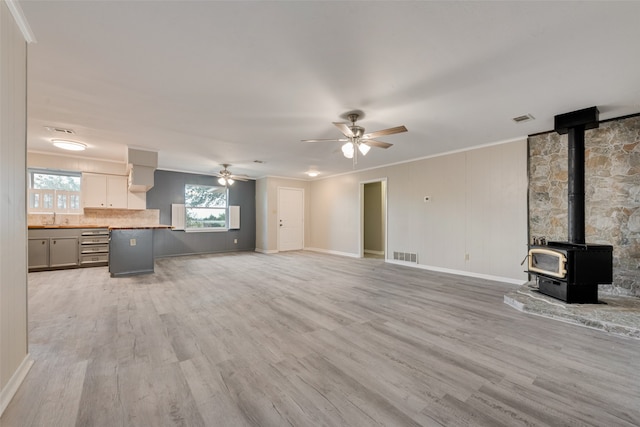 unfurnished living room featuring sink, ornamental molding, light hardwood / wood-style flooring, and ceiling fan