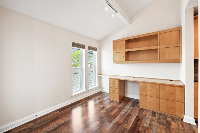 unfurnished office with lofted ceiling, dark hardwood / wood-style flooring, built in desk, and track lighting