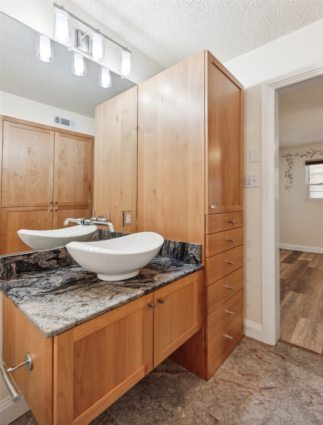 bathroom with vanity, a textured ceiling, and hardwood / wood-style flooring