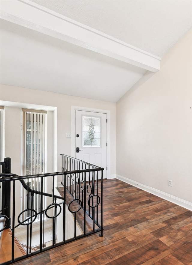 interior space with vaulted ceiling with beams, a wealth of natural light, and dark wood-type flooring