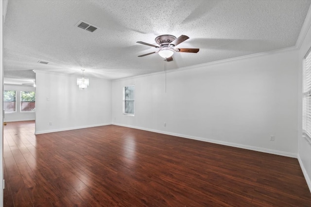 empty room with ornamental molding, dark wood-type flooring, a textured ceiling, and ceiling fan with notable chandelier