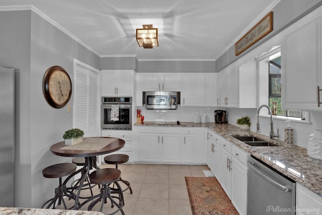 kitchen featuring decorative backsplash, sink, white cabinets, and stainless steel appliances