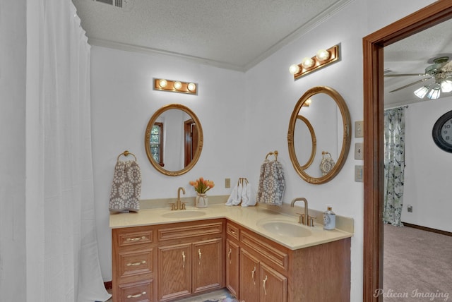 bathroom featuring ceiling fan, vanity, a textured ceiling, and ornamental molding