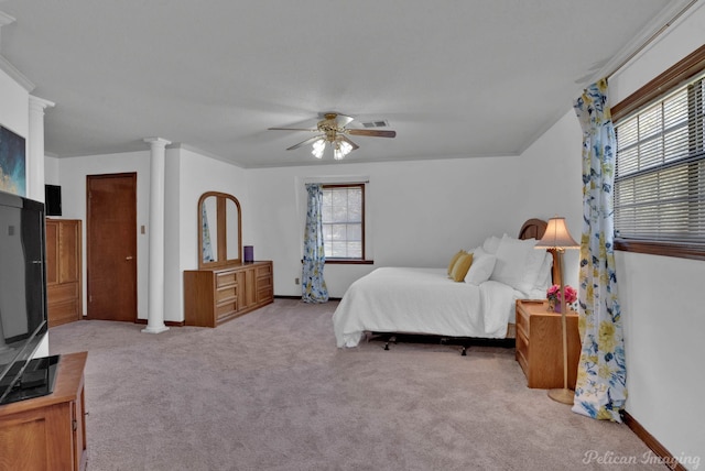 bedroom featuring ceiling fan, decorative columns, light carpet, and multiple windows