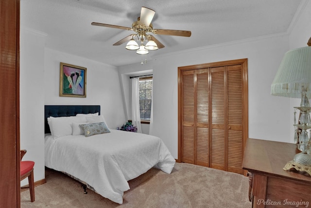 carpeted bedroom with a textured ceiling, ceiling fan, crown molding, and a closet