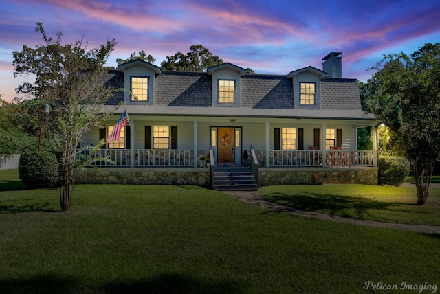 cape cod home with a yard and a porch