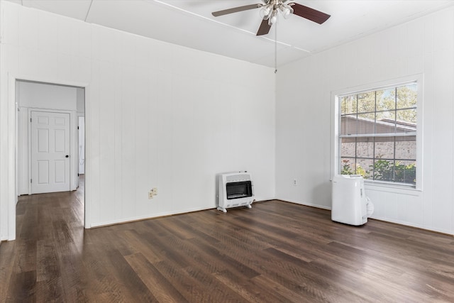 unfurnished room featuring dark hardwood / wood-style flooring, ceiling fan, and heating unit