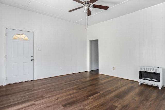 unfurnished living room with wooden walls, ceiling fan, dark hardwood / wood-style floors, and heating unit