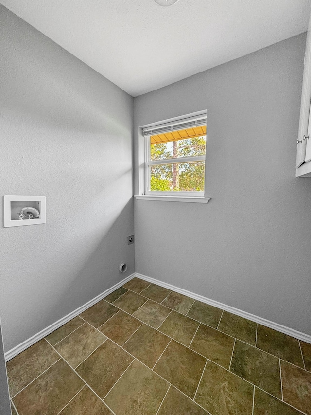 clothes washing area featuring dark tile patterned floors, hookup for a washing machine, hookup for an electric dryer, and cabinets