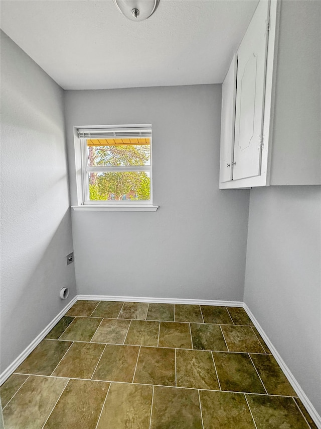 clothes washing area featuring cabinets and electric dryer hookup