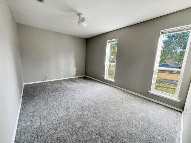 carpeted spare room featuring ceiling fan