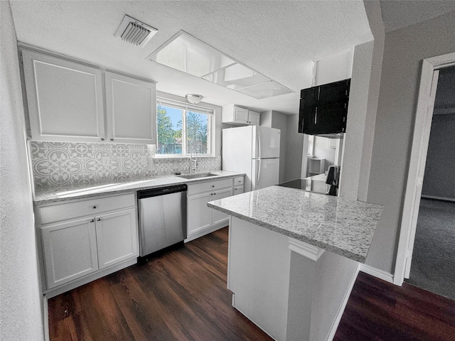 kitchen featuring dark hardwood / wood-style floors, sink, white refrigerator, white cabinetry, and dishwasher