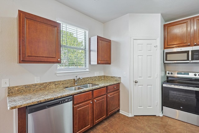 kitchen with light stone countertops, appliances with stainless steel finishes, sink, and light tile patterned floors