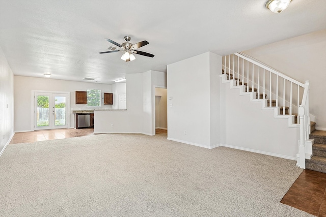 unfurnished living room featuring french doors, light colored carpet, and ceiling fan