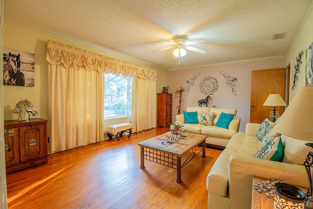 living room featuring ceiling fan, a textured ceiling, crown molding, and hardwood / wood-style flooring