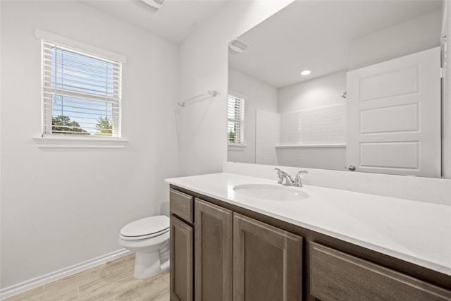 bathroom featuring toilet, walk in shower, hardwood / wood-style flooring, and vanity