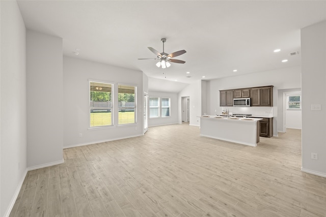 unfurnished living room featuring sink, ceiling fan, light hardwood / wood-style flooring, and plenty of natural light